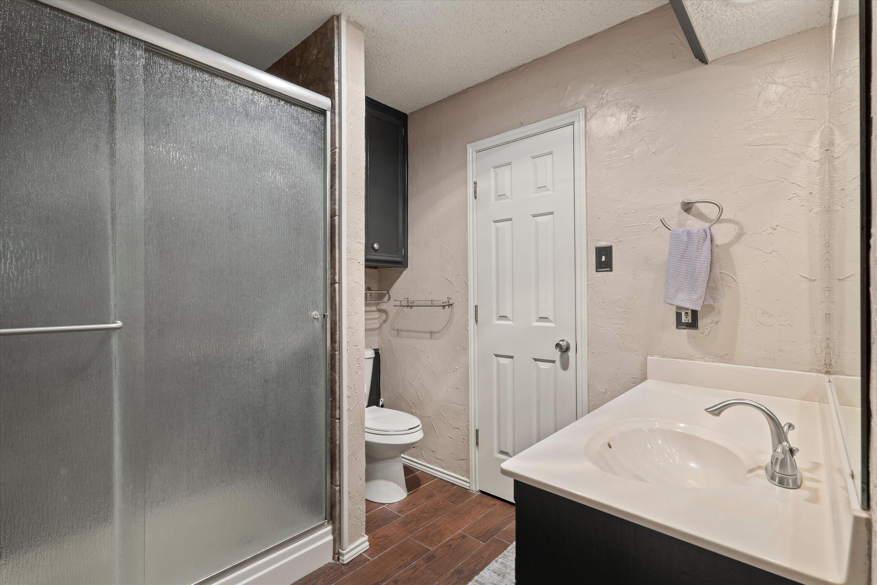 2308 93rd Street Lubbock, TX 79423 - Photo 16 of 28 a bathroom with a sink and mirror with toilet