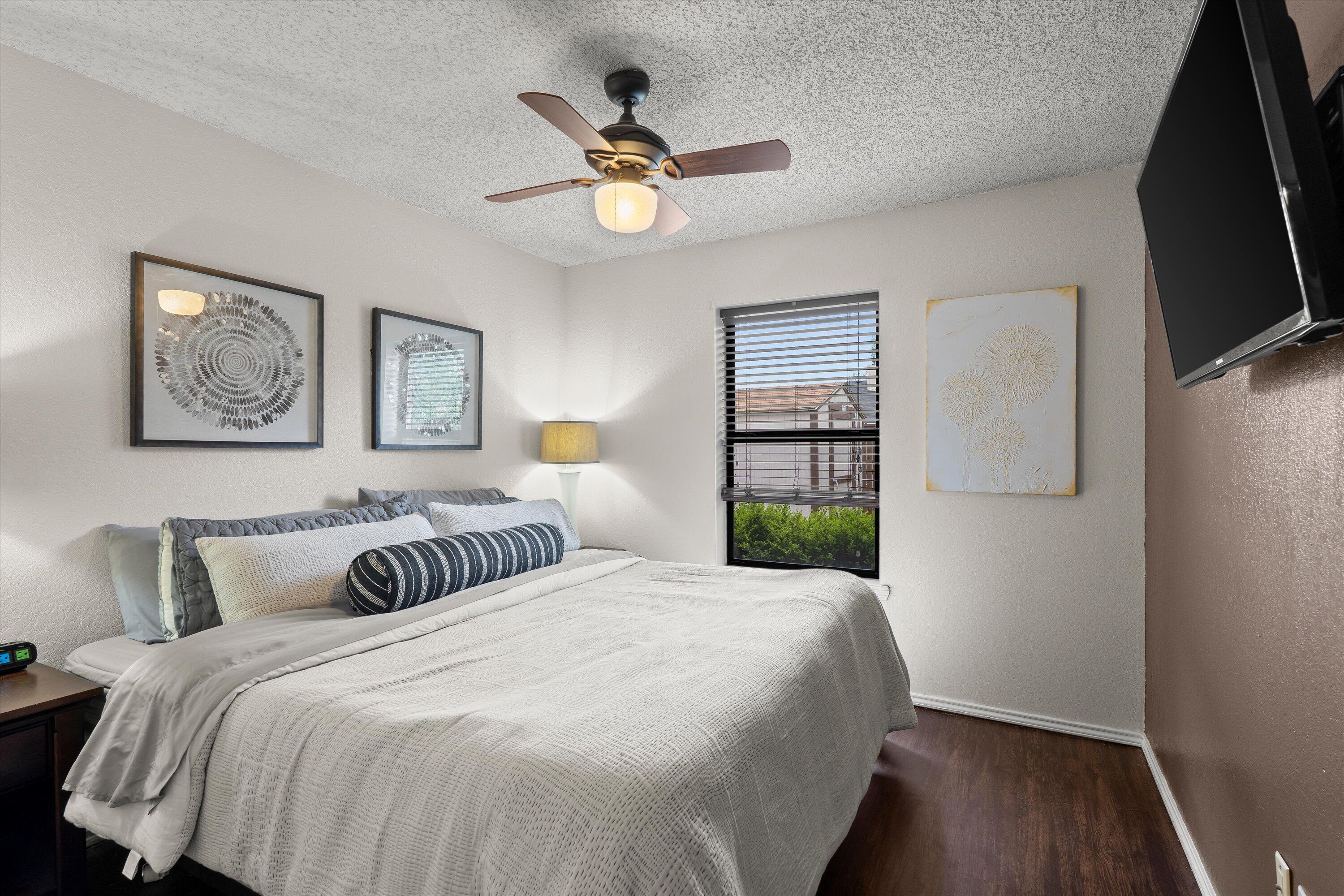 2308 93rd Street Lubbock, TX 79423 - Photo 18 of 28 a bedroom with a bed and a chandelier