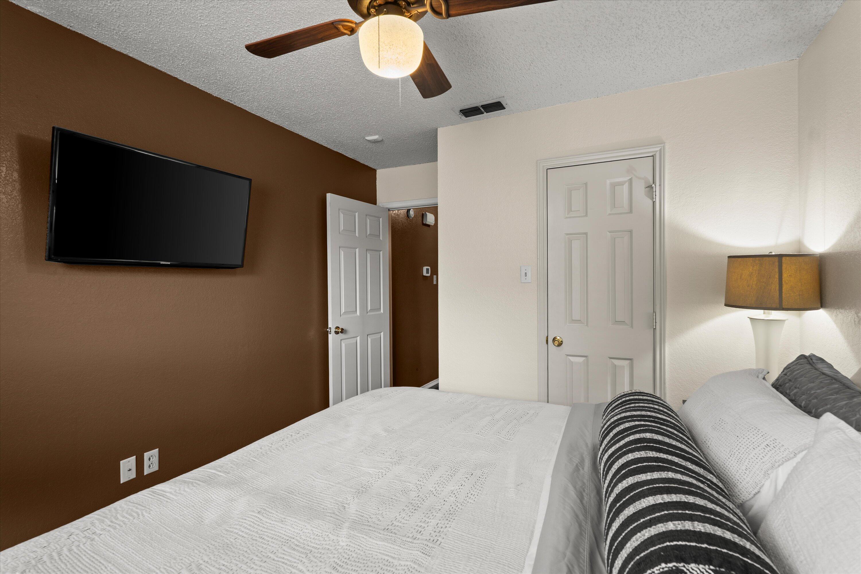 2308 93rd Street Lubbock, TX 79423 - Photo 19 of 28 a bedroom with a bed and a flat screen tv