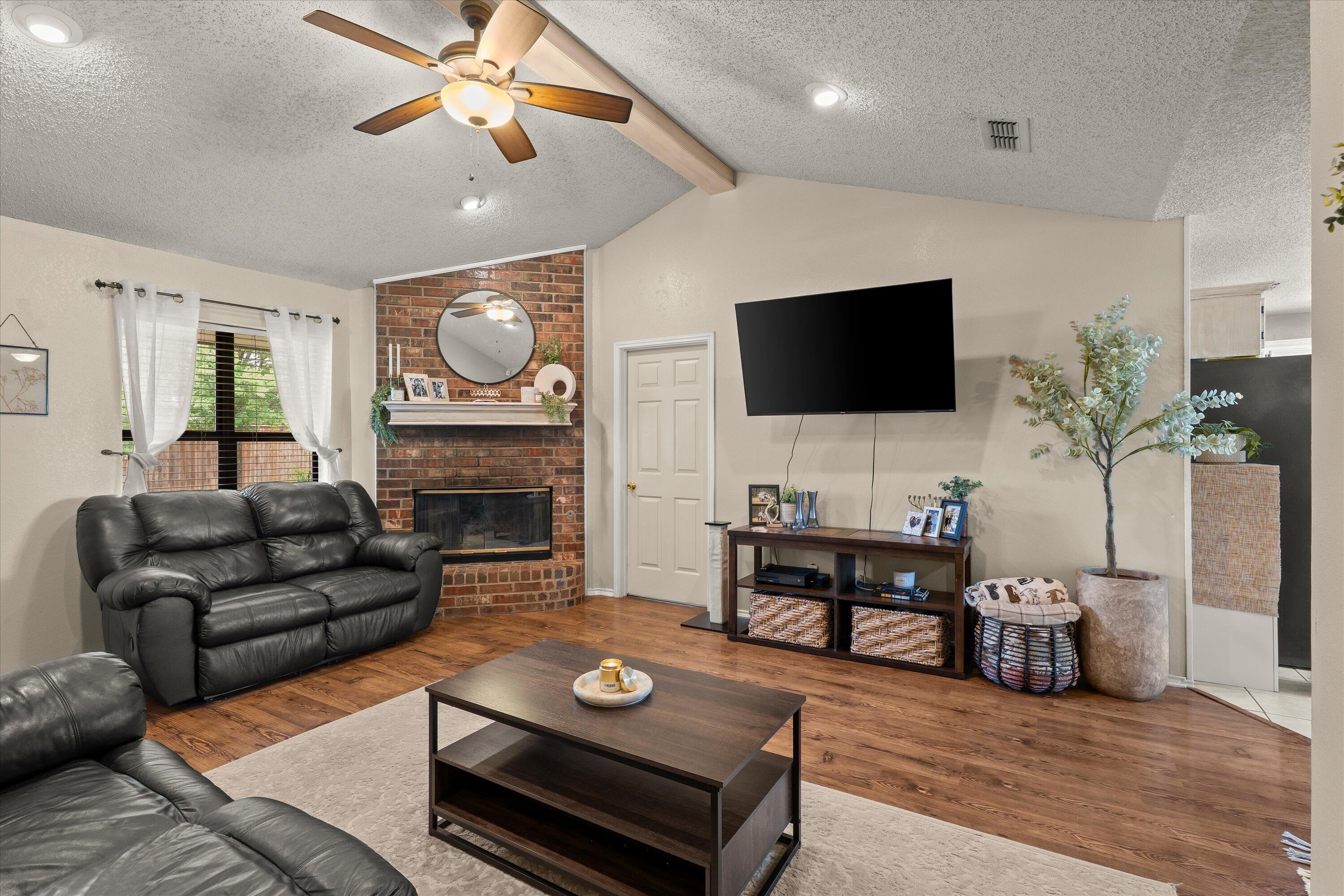 2308 93rd Street Lubbock, TX 79423 - Photo 7 of 28 a living room with furniture a fireplace and a flat screen tv