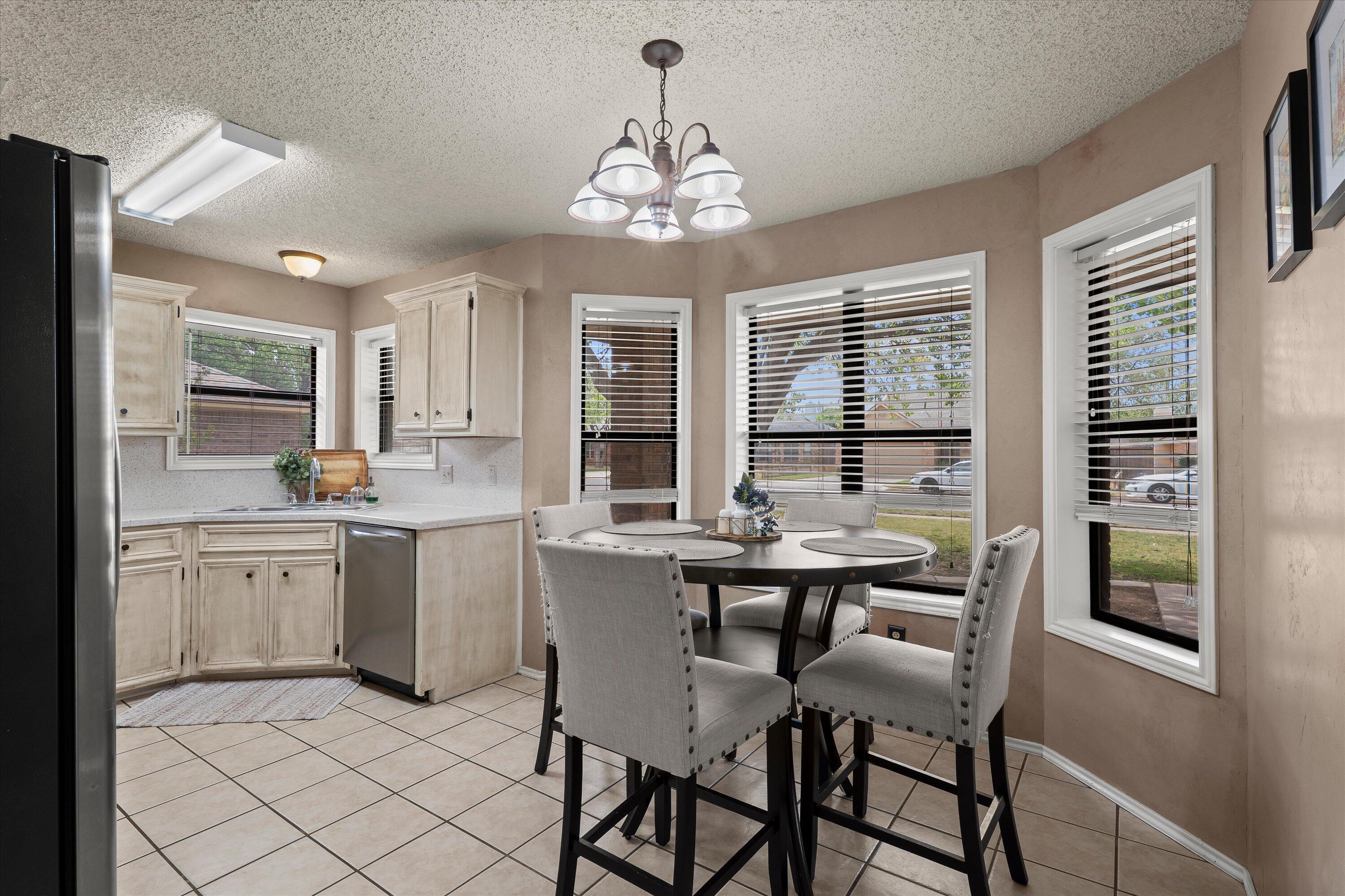 2308 93rd Street Lubbock, TX 79423 - Photo 10 of 28 a very nice looking kitchen with granite countertop a stove top oven a sink a dining table and chairs