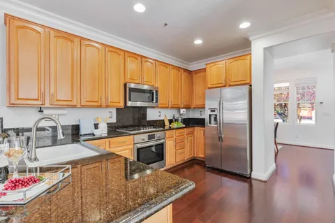 a kitchen with stainless steel appliances granite countertop a refrigerator stove top oven and sink