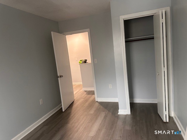 259 Westchester Road, Unit A Colchester, CT 06415 - Photo 16 of 22 an empty room with wooden floor and a hallway