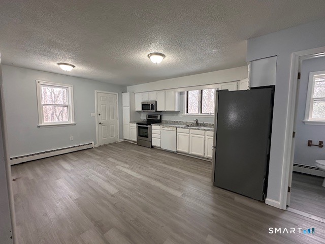 259 Westchester Road, Unit A Colchester, CT 06415 - Photo 3 of 22 a view of a kitchen with a refrigerator a stove top oven and cabinets