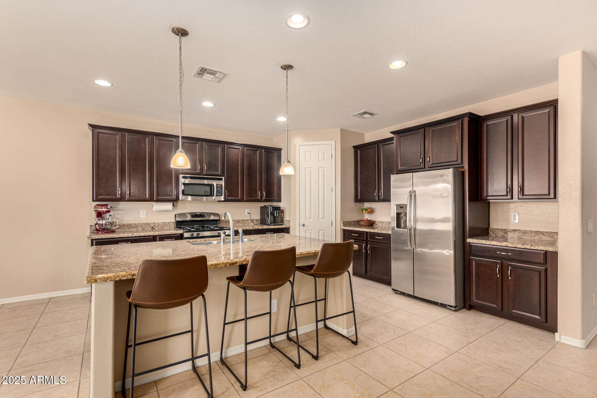 3294 North Springfield Street Buckeye, AZ 85396 - Photo 11 of 43 a kitchen with stainless steel appliances granite countertop a refrigerator a stove a sink a microwave and a refrigerator