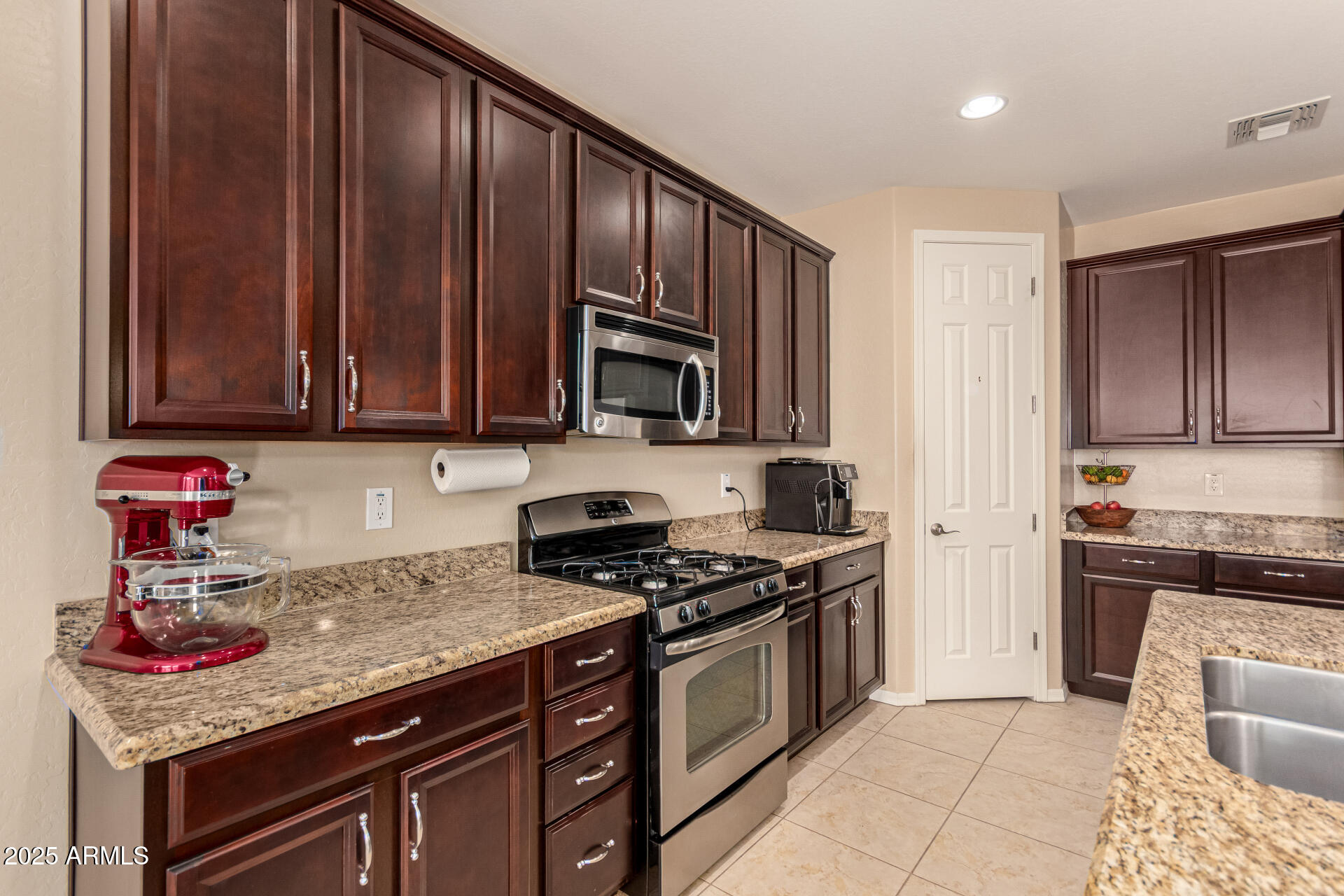 3294 North Springfield Street Buckeye, AZ 85396 - Photo 14 of 43 a kitchen with stainless steel appliances granite countertop a stove and a microwave