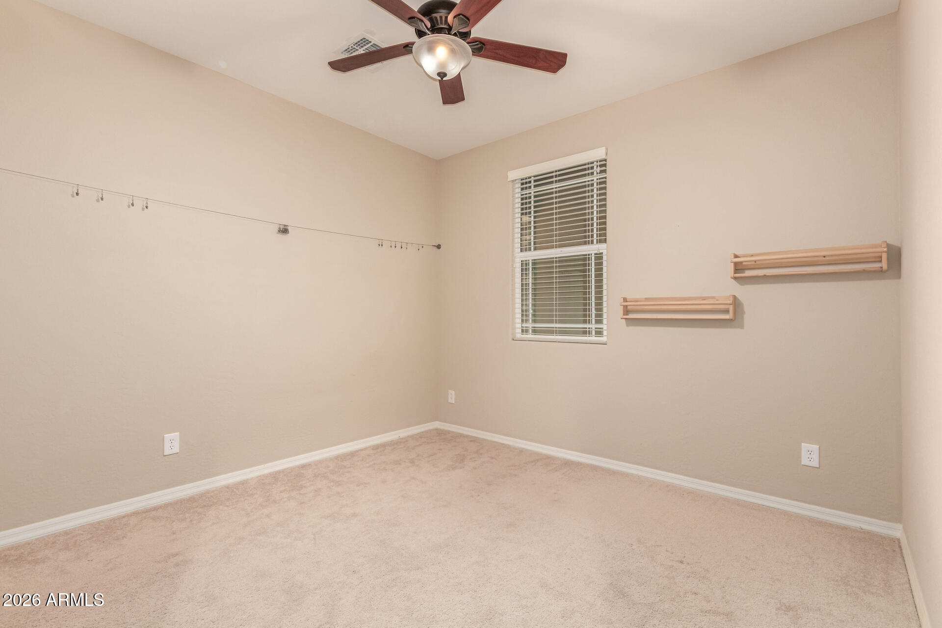 3294 North Springfield Street Buckeye, AZ 85396 - Photo 21 of 43 an empty room with a window and a fan