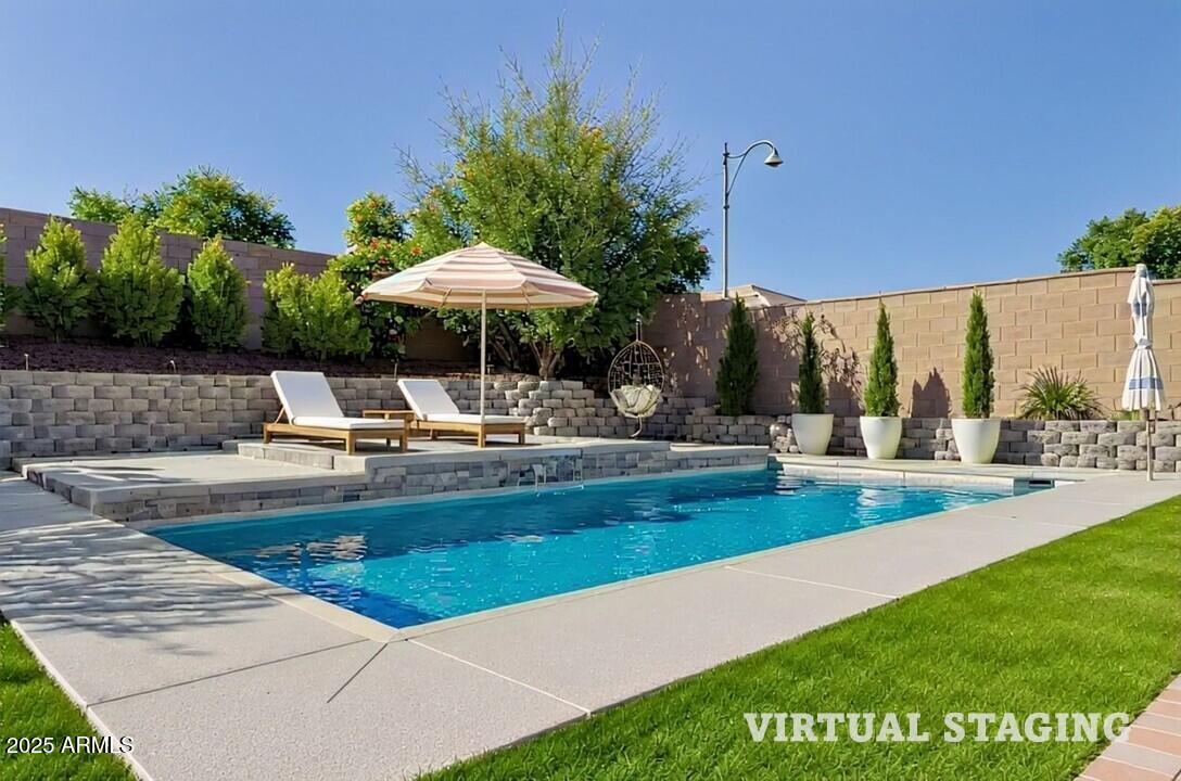 3294 North Springfield Street Buckeye, AZ 85396 - Photo 32 of 43 a view of a swimming pool with a table and chairs under an umbrella