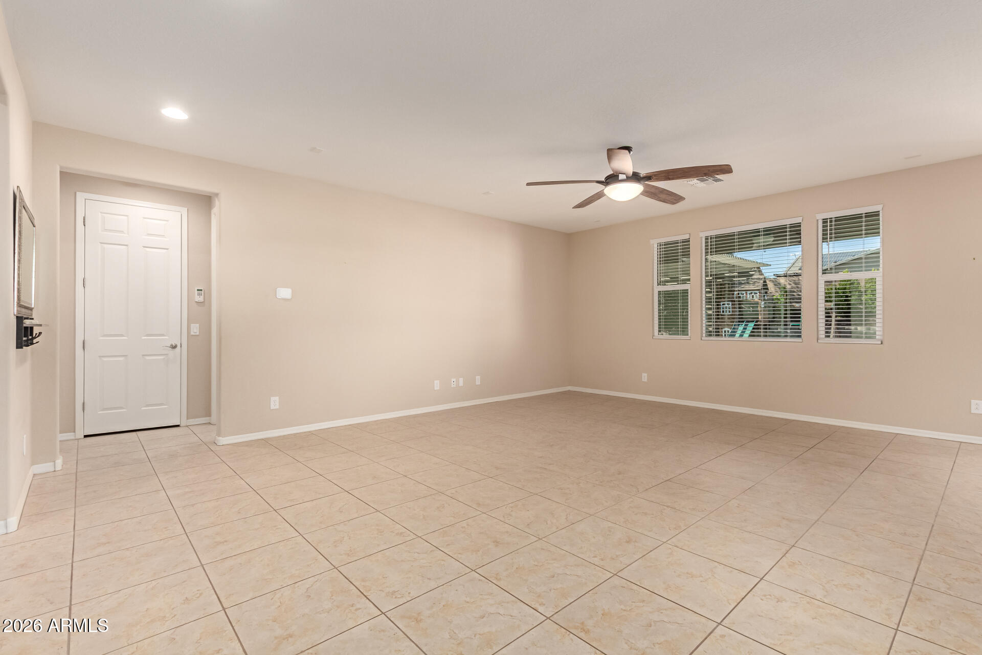 3294 North Springfield Street Buckeye, AZ 85396 - Photo 5 of 43 an empty room with chandelier fan and windows