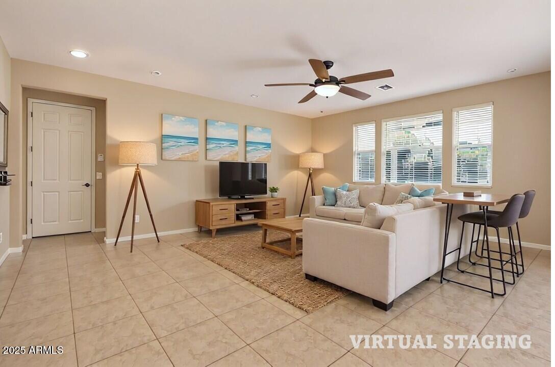 3294 North Springfield Street Buckeye, AZ 85396 - Photo 8 of 43 a living room with furniture a flat screen tv and a large window