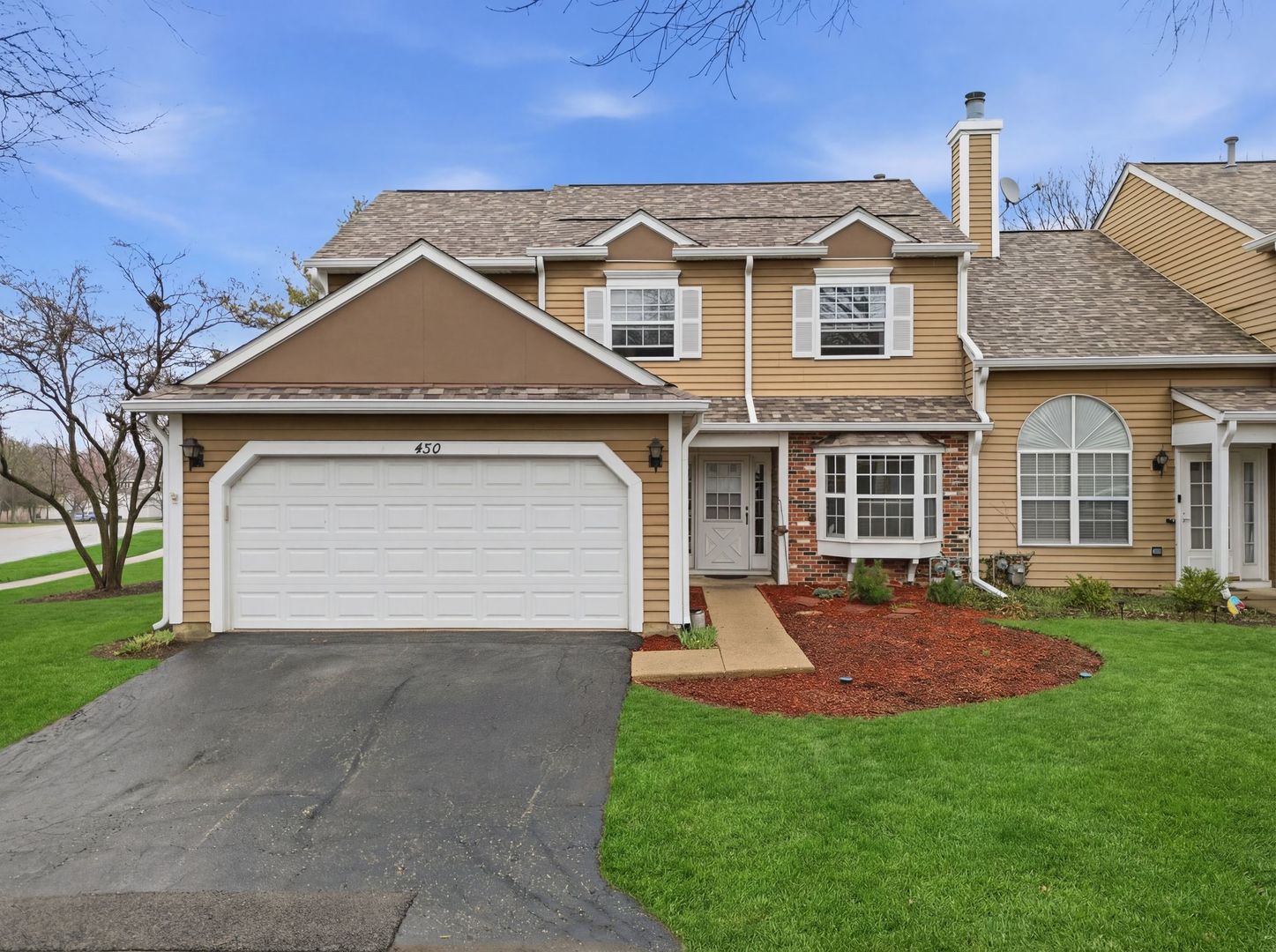 450 Ascot Lane Streamwood, IL 60107 - Photo 1 of 27 a front view of a house with a garden and yard