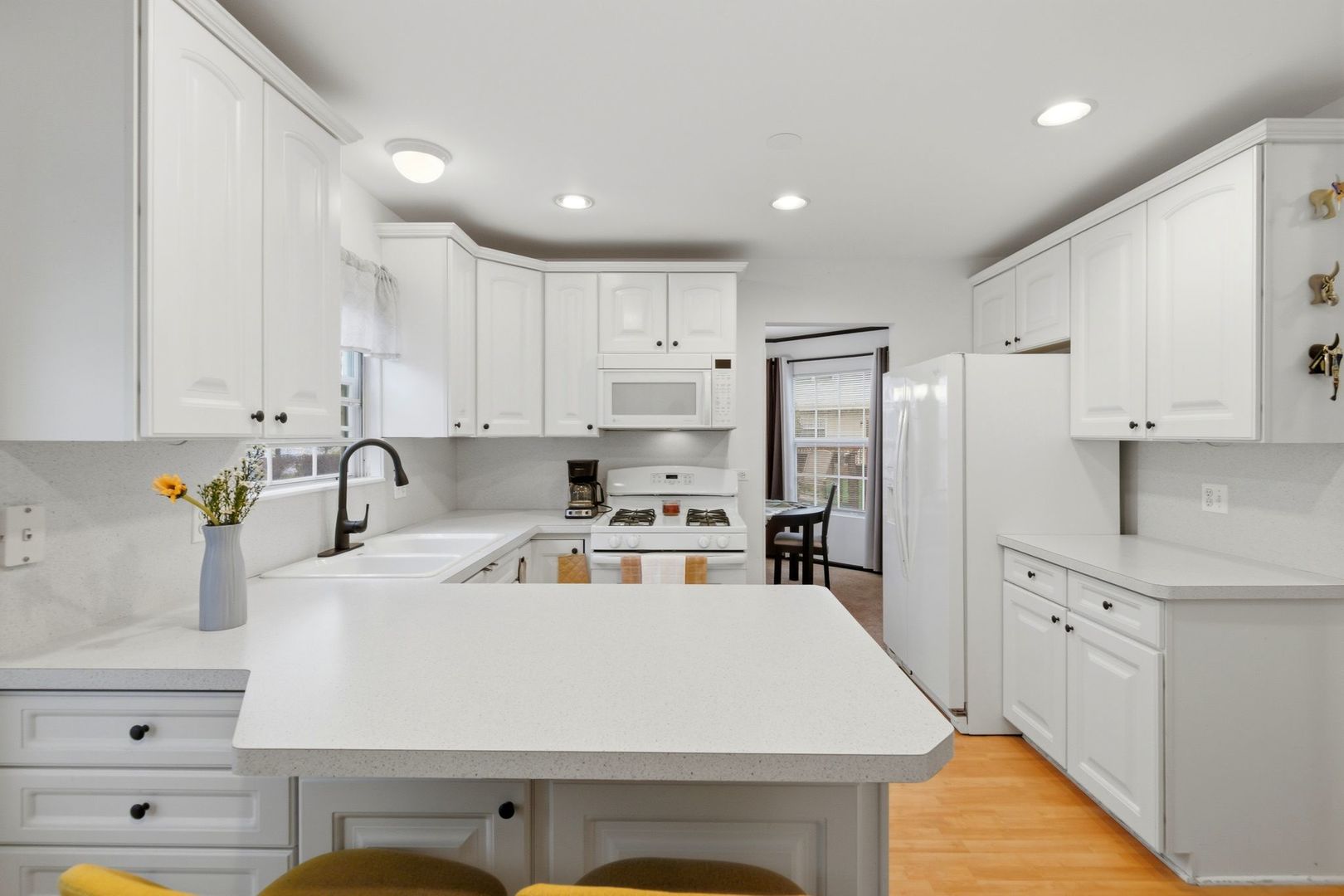 450 Ascot Lane Streamwood, IL 60107 - Photo 14 of 27 a kitchen with kitchen island a stove a sink a refrigerator and white cabinets with wooden floor