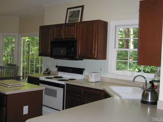 5616 Raddington Street Raleigh, NC 27613 - Photo 5 of 10 a kitchen with a sink a stove and a microwave