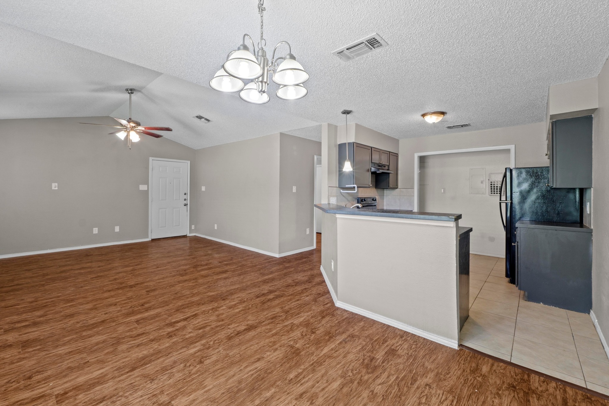 4208 Duval Road, Unit C Austin, TX 78759 - Photo 7 of 28 Kitchen featuring ceiling fan, light wood-style floors, a chandelier, pendant lighting, and lofted ceiling