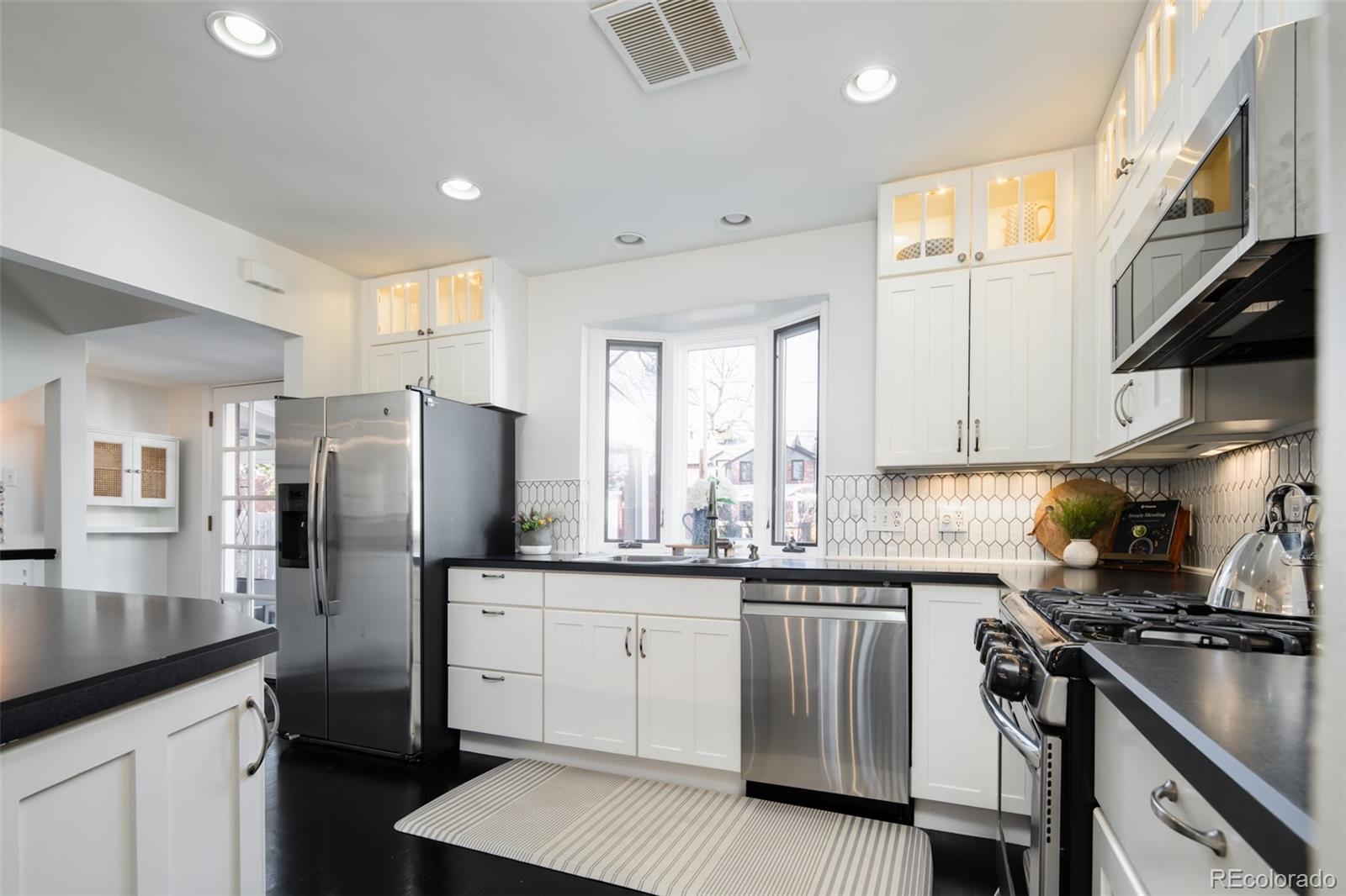 457 Elm Street Denver, CO 80220 - Photo 14 of 45 a kitchen with stainless steel appliances granite countertop a sink stove and refrigerator