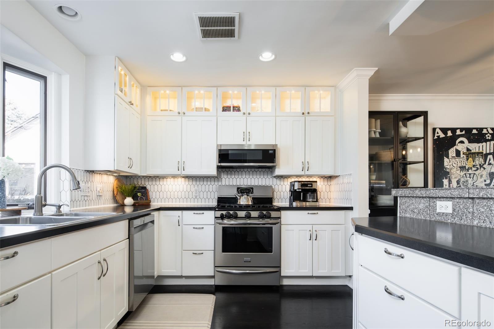 457 Elm Street Denver, CO 80220 - Photo 15 of 45 a kitchen with stainless steel appliances granite countertop white cabinets a sink a stove and a refrigerator