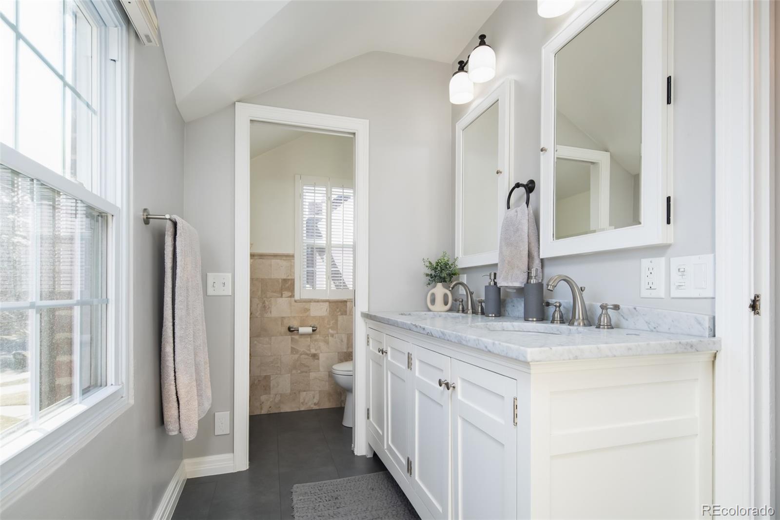 457 Elm Street Denver, CO 80220 - Photo 19 of 45 a bathroom with a double vanity sink and a mirror
