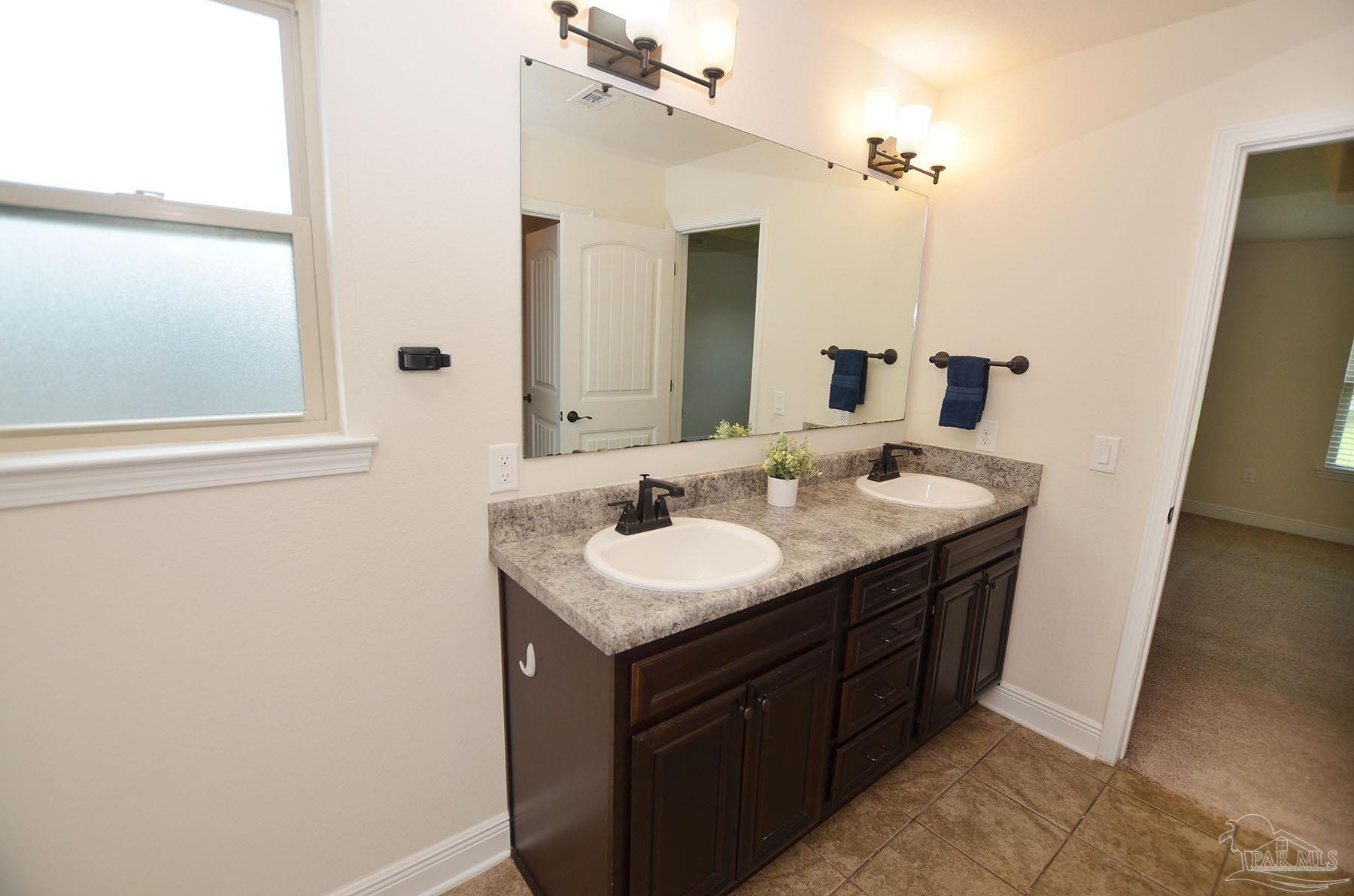 5709 Mill Stream Way Pace, FL 32571 - Photo 26 of 48 a bathroom with a sink and a mirror