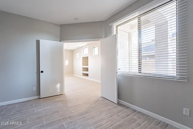 an empty room with closet and a chandelier fan
