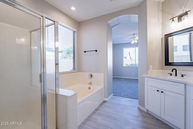 a bathroom with a tub a sink and mirror