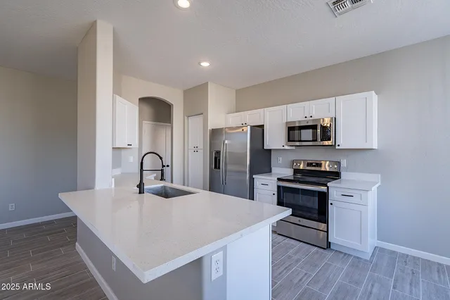 a kitchen with a sink cabinets and wooden floor