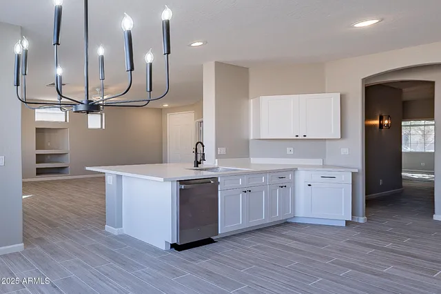 a kitchen with stainless steel appliances granite countertop a refrigerator a stove a sink and a wooden floors