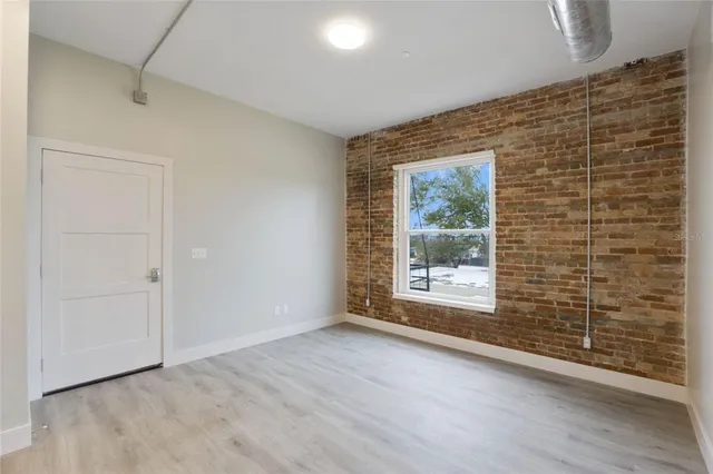 a kitchen with stainless steel appliances granite countertop a stove a microwave oven a sink dishwasher and white cabinets with wooden floor