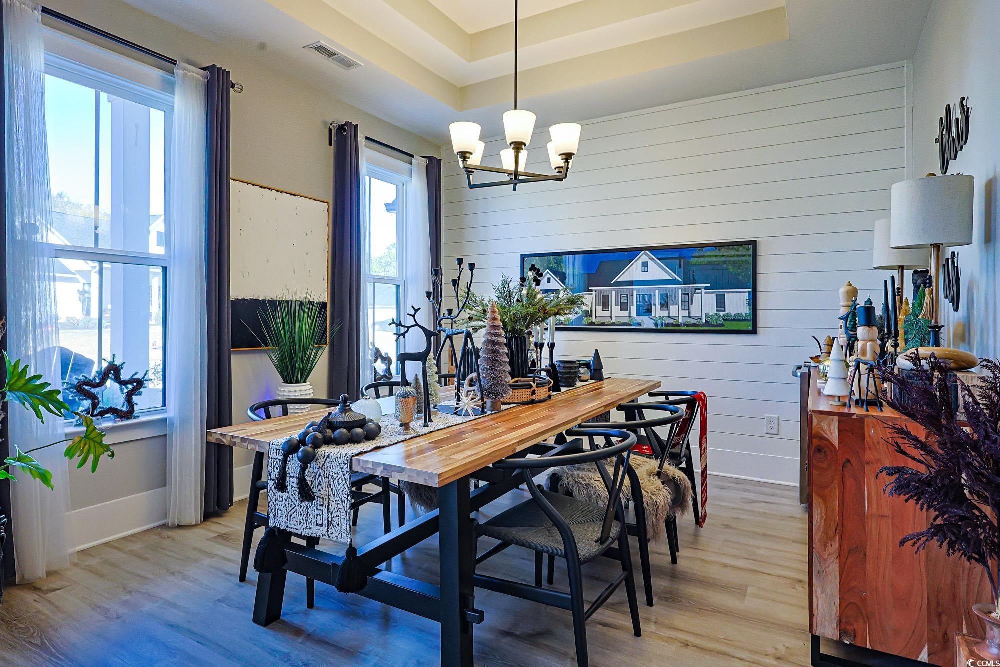 669 Pacific Commons Drive Surfside Beach, SC 29575 - Photo 14 of 36 Dining area with wood walls, light wood finished floors, a tray ceiling, and a chandelier
