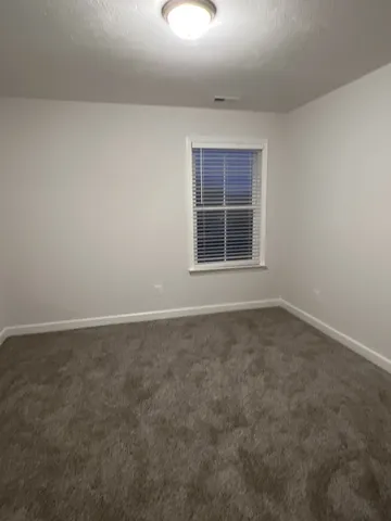 en empty room with windows and fan