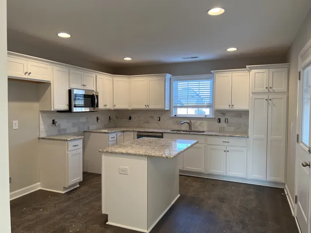 a kitchen with stainless steel appliances granite countertop a stove a sink dishwasher and a refrigerator