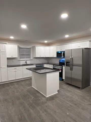 a kitchen with stainless steel appliances granite countertop a refrigerator and a stove top oven