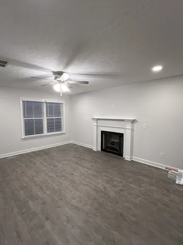 an empty room with windows and fireplace