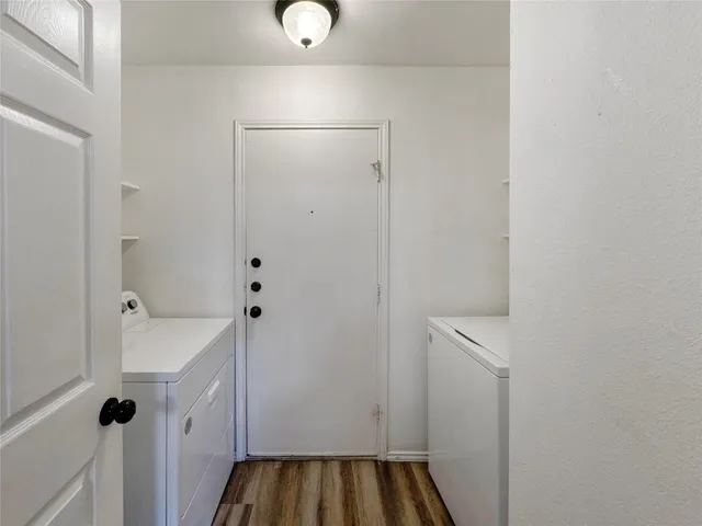 a view of a hallway with wooden floor and closet area