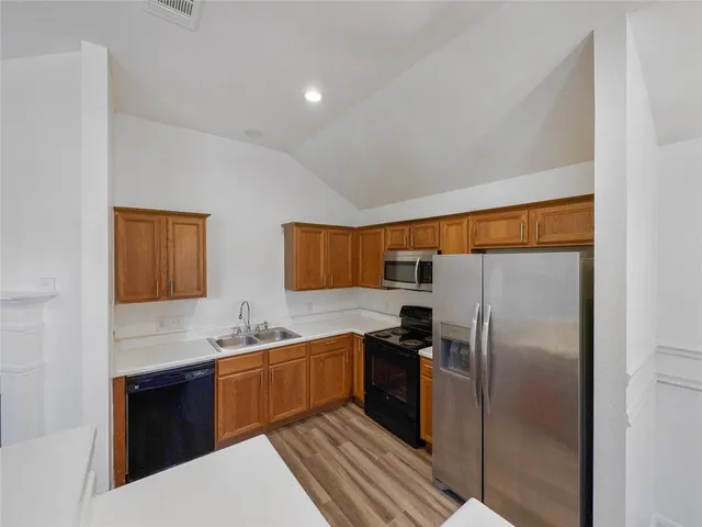 a view of a kitchen with wooden floor and a sink