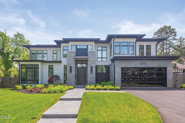 a front view of a house with a garden and yard
