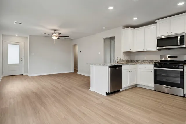 a view of kitchen with granite countertop cabinets and wooden floor