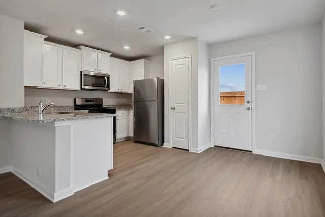 a kitchen with stainless steel appliances a refrigerator sink and microwave