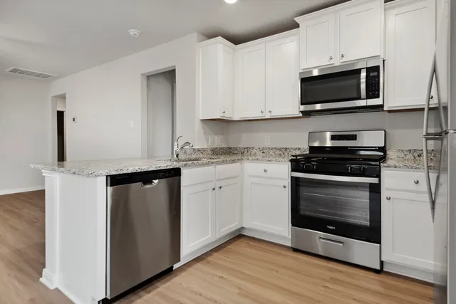 a kitchen with appliances a sink and cabinets
