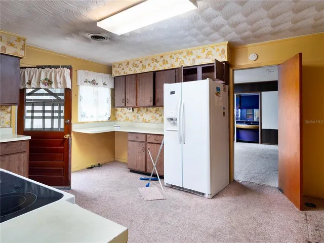 a kitchen with refrigerator and window