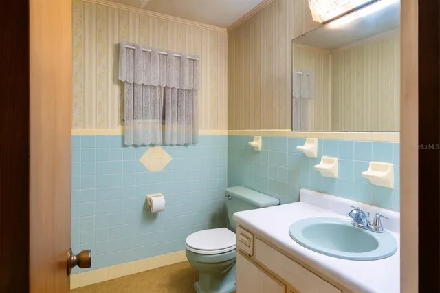 a bathroom with a sink a toilet and mirror