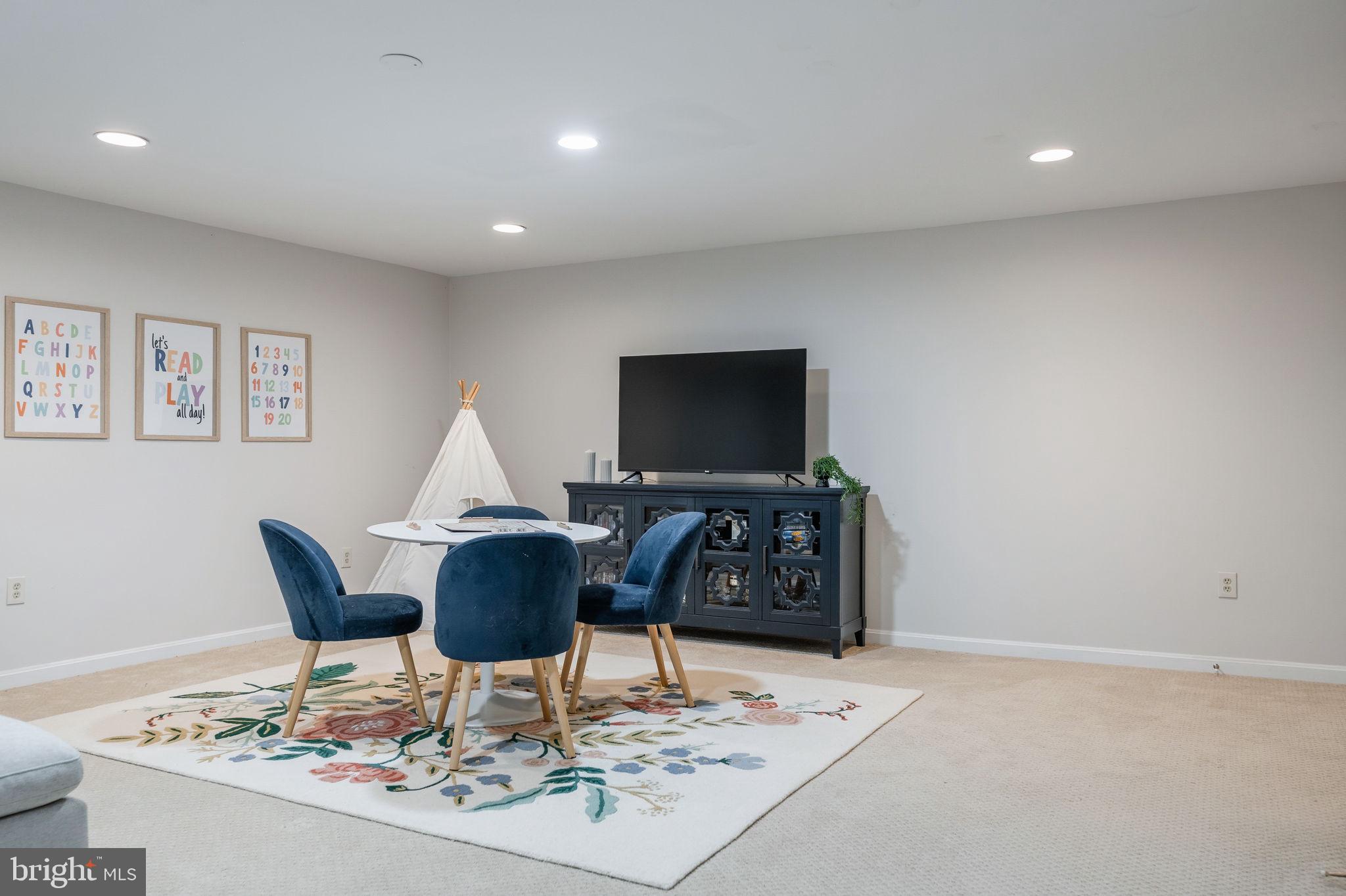 7603 Modisto Lane Springfield, VA 22153 - Photo 39 of 57 a dining room with furniture a rug and a flat screen tv