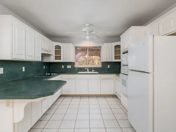 a kitchen with granite countertop white cabinets and window