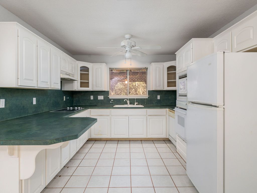 3707 Wyldwood Road Austin, TX 78739 - Photo 5 of 30 a kitchen with stainless steel appliances granite countertop a sink a stove a refrigerator and cabinets