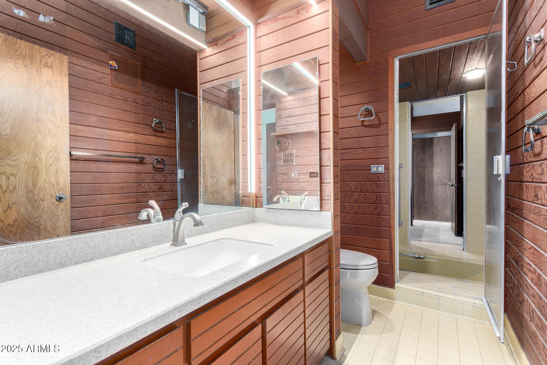 5275 North Camelhead Road Phoenix, AZ 85251 - Photo 48 of 72 a bathroom with a sink and a large mirror
