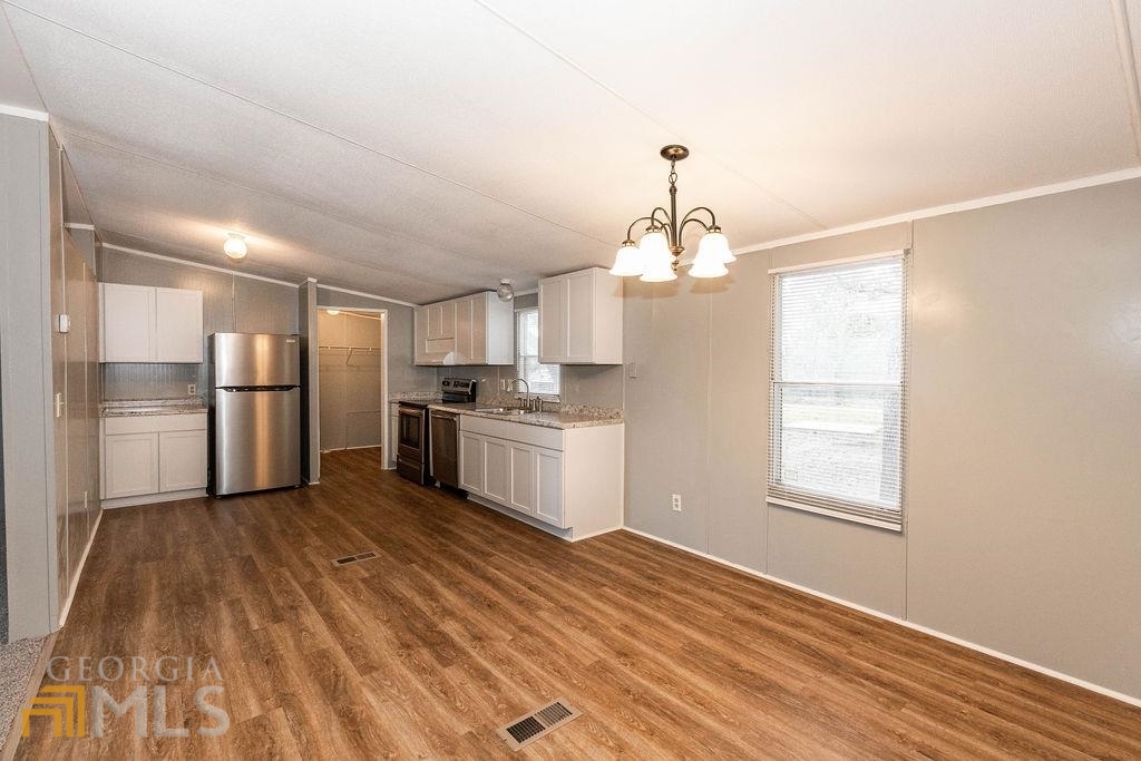 108 Sherwood Road Rincon, GA 31326 - Photo 14 of 28 a kitchen with stainless steel appliances granite countertop a refrigerator a sink dishwasher a stove and white countertops with wooden floor