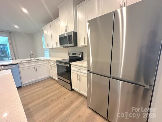 a kitchen with stainless steel appliances a refrigerator a sink a stove a microwave and cabinetry