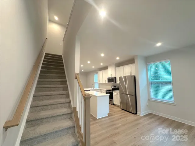 a view of kitchen with refrigerator and wooden floor