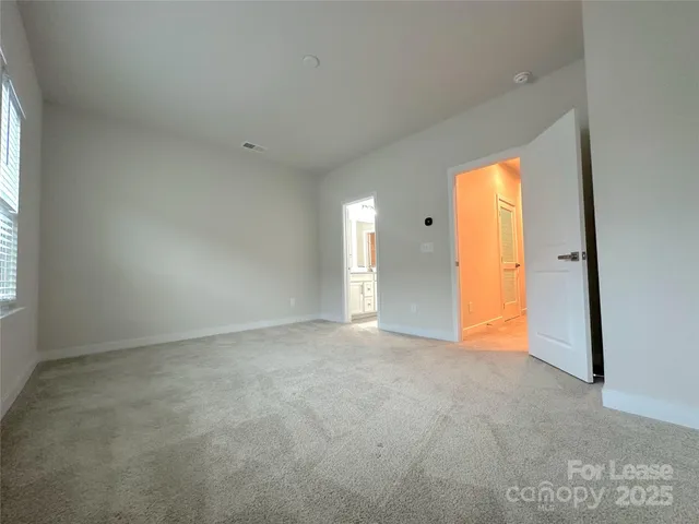 an empty room with window and a ceiling fan