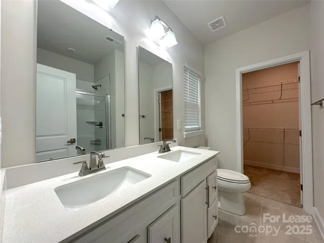 a bathroom with a sink double vanity and a toilet