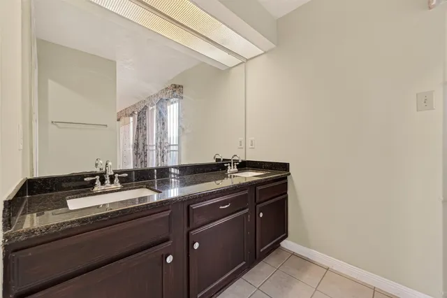 a view of an empty room with window and chandelier fan